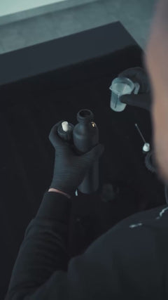 Man vult een sprayfles met vloeistof en gebruikt de fles om te sprayen